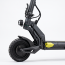 Close-up side view of a black electric scooter with a carbon-fiber-look frame, black tire, front light, and a bright yellow accent near the deck, photographed on a clean white background.