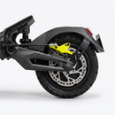 Close-up of a black carbon-fiber-look motorcycle or scooter rear wheel with a bright yellow brake caliper, silver disc brake, and black tire on a light gray studio background.
